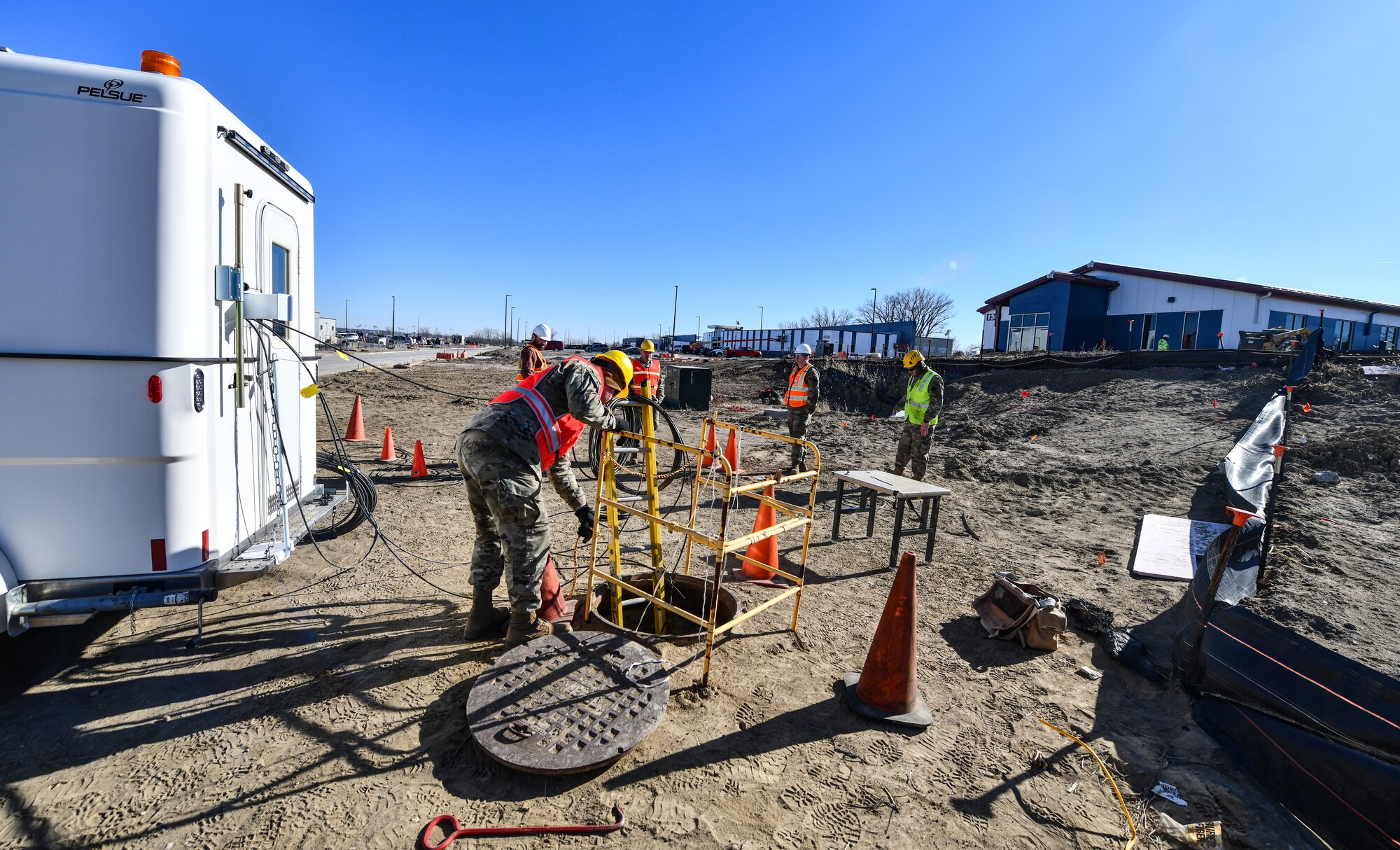 Members of the 243rd Engineering and Istallation Squadron, Maine Air National Guard, work on splicing and connecting fiber optic cable to the new campus construction sites on Offutt Air Force Base, Jan. 29, 2025. Using members of the Maine ANG saved the government over $150 thousand on labor costs. (U.S. Air Force photo by Chad Watkins)