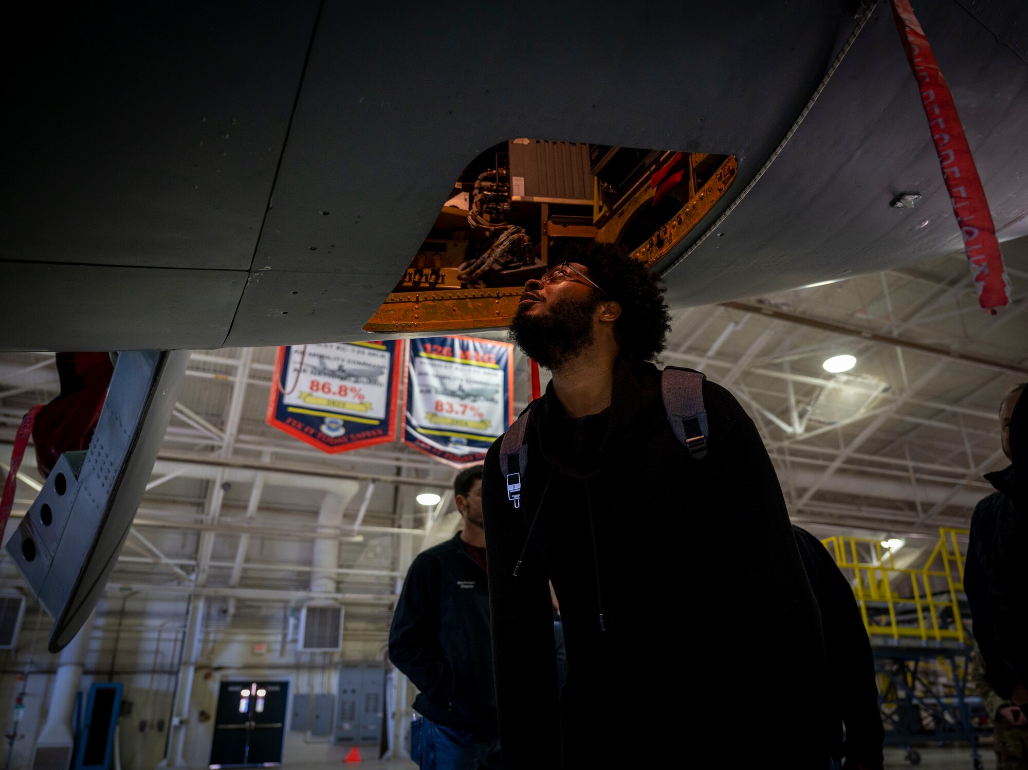 Nick Skinner peers inside a KC-135 from beneath the air craft.