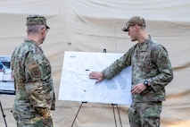 U.S. Air Force Brig. Gen. Anthony Babcock, Air Mobility Command director of logistics, engineering and force protection, receives a brief from 1st Lt. Calvin Ciganik, 628th Civil Engineer Squadron section commander, about 628th CES training facility expansion at Joint Base Charleston, South Carolina, Feb. 27, 2025.