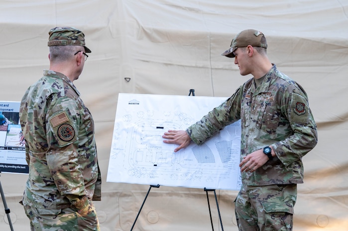 U.S. Air Force Brig. Gen. Anthony Babcock, Air Mobility Command director of logistics, engineering and force protection, receives a brief from 1st Lt. Calvin Ciganik, 628th Civil Engineer Squadron section commander, about 628th CES training facility expansion at Joint Base Charleston, South Carolina, Feb. 27, 2025.