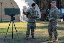 U.S. Air Force Tech. Sgt. Xavier Alvarez, 628th Security Forces Squadron counter-small unmanned aircraft system program manager, briefs Brig. Gen. Anthony Babcock, Air Mobility Command director of logistics, engineering and force protection at Joint Base Charleston, South Carolina, Feb. 27, 2025.