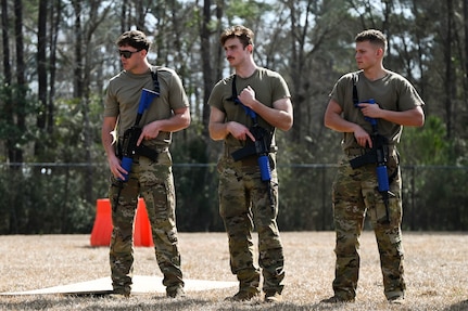 Three Airmen participate in a defensive fighting position familiarization course during BATTLE school.