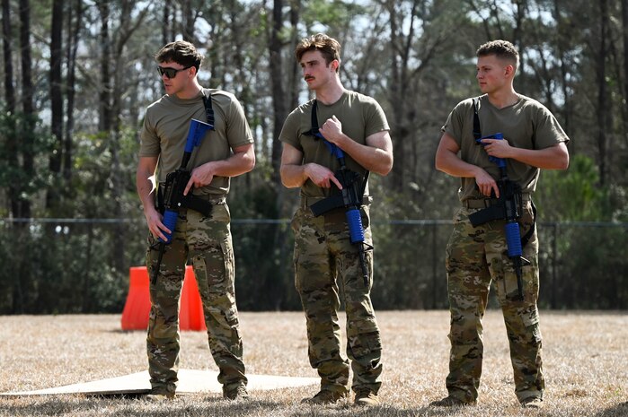 Three Airmen participate in a defensive fighting position familiarization course during BATTLE school.