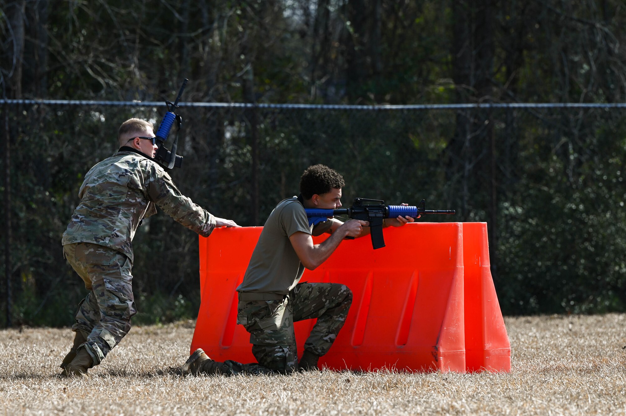 Two Airmen takes cover during a defensive fighting position familiarization course