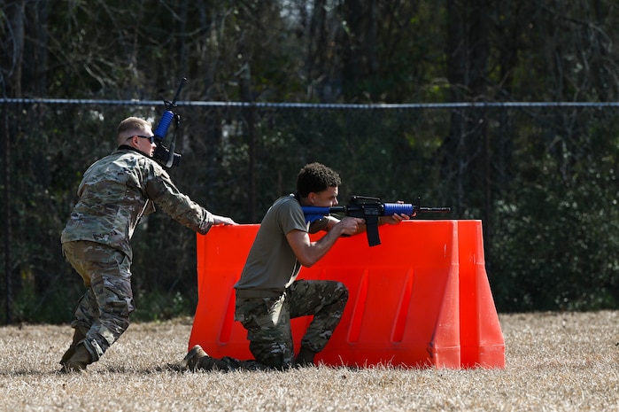 Two Airmen takes cover during a defensive fighting position familiarization course