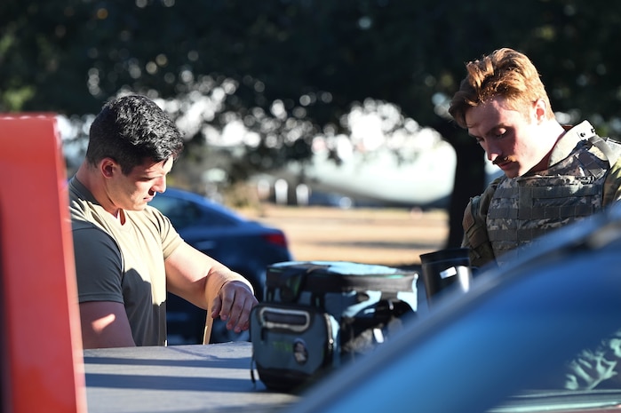 Airmen gear up in individual protective equipment before a field training exercise during BATTLE school.