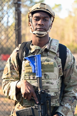 Airman stands with protective equipment during BATTLE school.