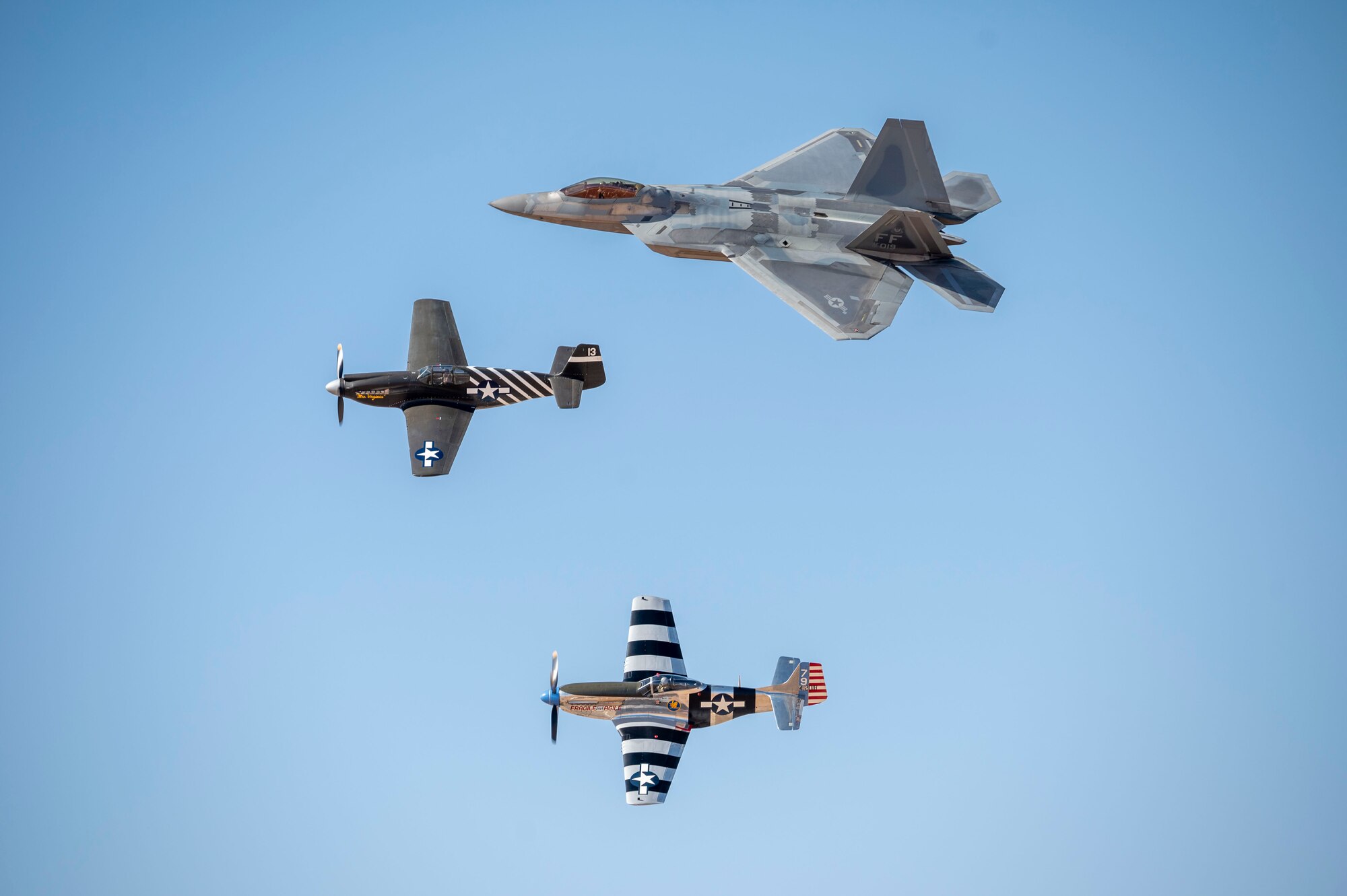 A U.S. Air Force F-22 Raptor aircraft flies in formation with two P-51 Mustang aircraft during Heritage Flight Training Course at Davis-Monthan Air Force Base, Arizona, Feb. 28, 2025. The HFTC provides experience to new members of the demonstration team, as well as providing an environment for returning members to hone their learned skills. (U.S. Air Force photo by Airman Samantha Melecio)