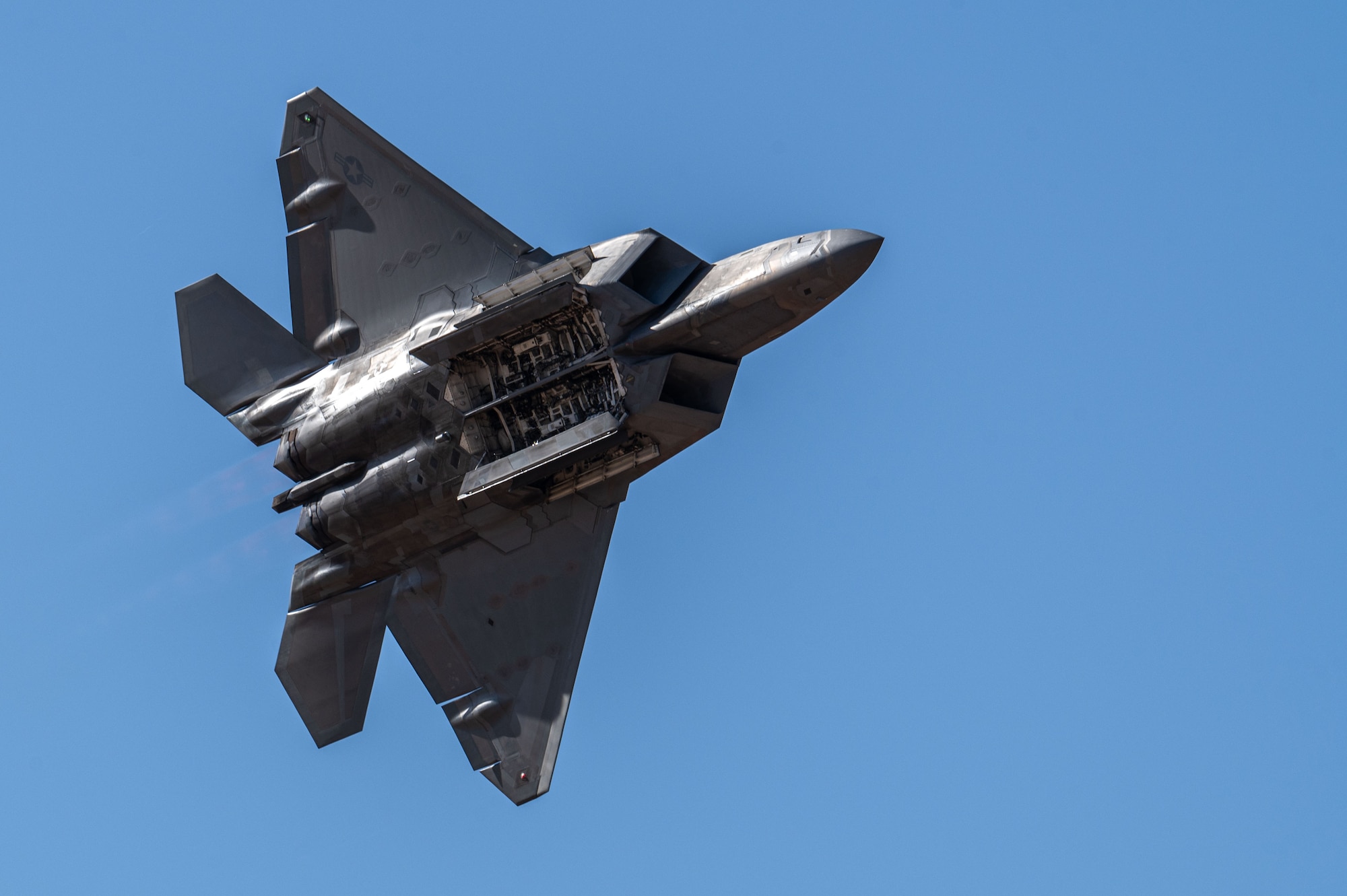 A U.S. Air Force F-22 Raptor aircraft displays its weapons bays during the Heritage Flight Training Course at Davis-Monthan Air Force Base, Arizona, Feb. 28, 2025. The F-22 Raptor Demonstration Team performs at airshows around the country, as well as internationally, to display the combat capabilities of the Air Force. (U.S. Air Force photo by Senior Airman Jasmyne Bridgers-Matos)