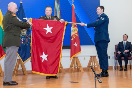 Maj. Gen. John Pippy, center, and Command Sgt. Maj. Shawn Phillips, left, unfurl Pippy's two-star flag during a ceremony Feb. 28, 2025, at Fort Indiantown Gap, Pa. During the ceremony, Pippy was sworn in as Pennsylvania’s 55th adjutant general and promoted to his current rank. (Pennsylvania National Guard photo by Wayne V. Hall)