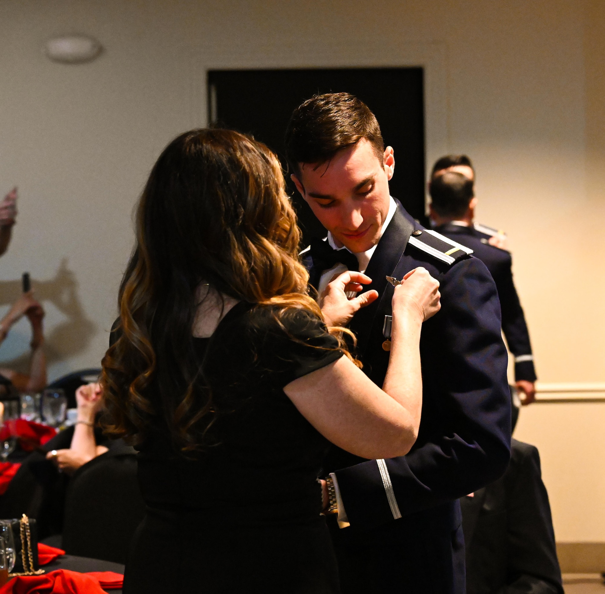 U.S. Air Force Airmen from graduating Class 25-06 present one half of their broken wings to their loved ones at Laughlin Air Force Base, Texas, Feb. 27, 2025.  Nineteen U.S. Air Force officers were awarded silver wings during the ceremony, symbolizing their completion of the Undergraduate Pilot Training program. (U.S. Air Force photo by Airman 1st Class Harrison Sullivan)