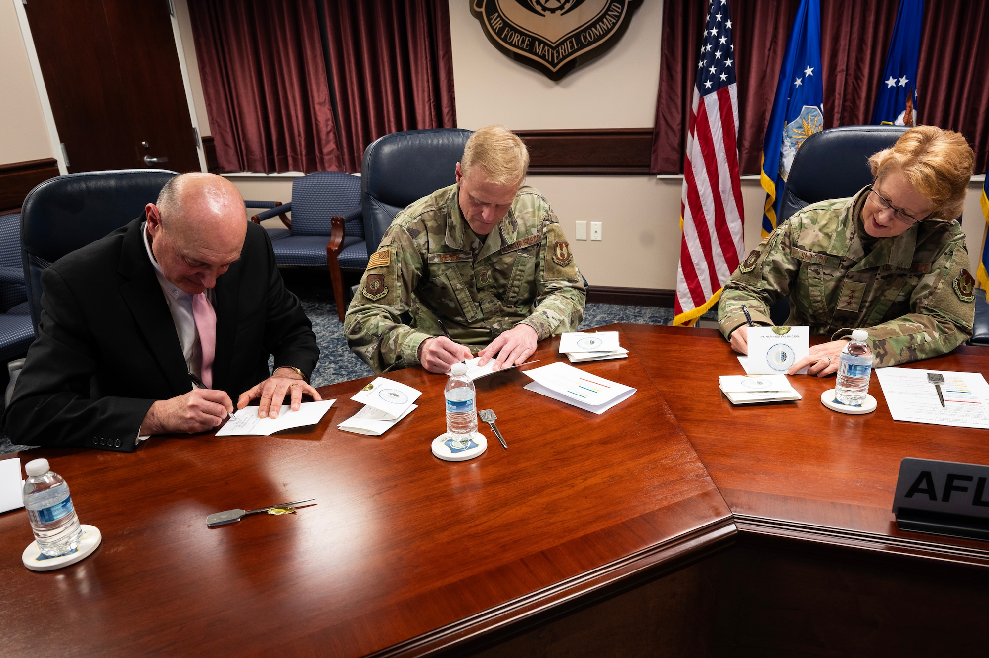 Following the Air Force Life Cycle Management Center’s annual award ceremony held on Wright-Patterson Air Force Base, Ohio, Feb 27. 2025, the Center’s leaders commander Lt. Gen. Donna Shipton (right), executive director Dennis D’Angelo (left) and command chief, Chief Master Sgt. Timothy Wieser signed personal notes to the award winners of the categories they each announced during the ceremony. The event was held virtually so all of the Center’s various organizations located throughout the country could participate. (U.S. Air Force photo by Jim Varhegyi)