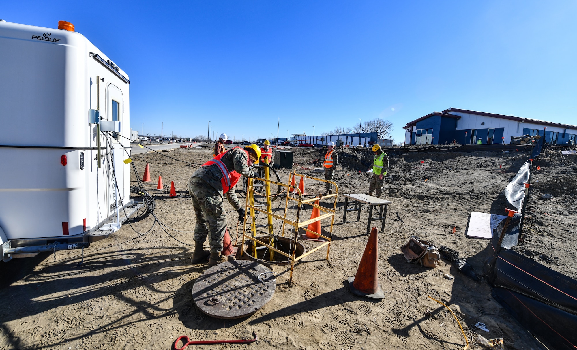 Members of the 243rd Engineering and Istallation Squadron, Maine Air National Guard, work on splicing and connecting fiber optic cable to the new campus construction sites on Offutt Air Force Base, Jan. 29, 2025. Using members of the Maine ANG saved the government over $150 thousand on labor costs. (U.S. Air Force photo by Chad Watkins)