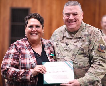 Gina Dickerson smiles after the United States Property and Fiscal Officer of Illinois, Col. Brian Creech presented her with the Illinois Military Medal of Merit.