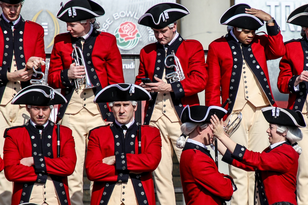 A group of old guard soldiers stand on bleachers and prepare to march.