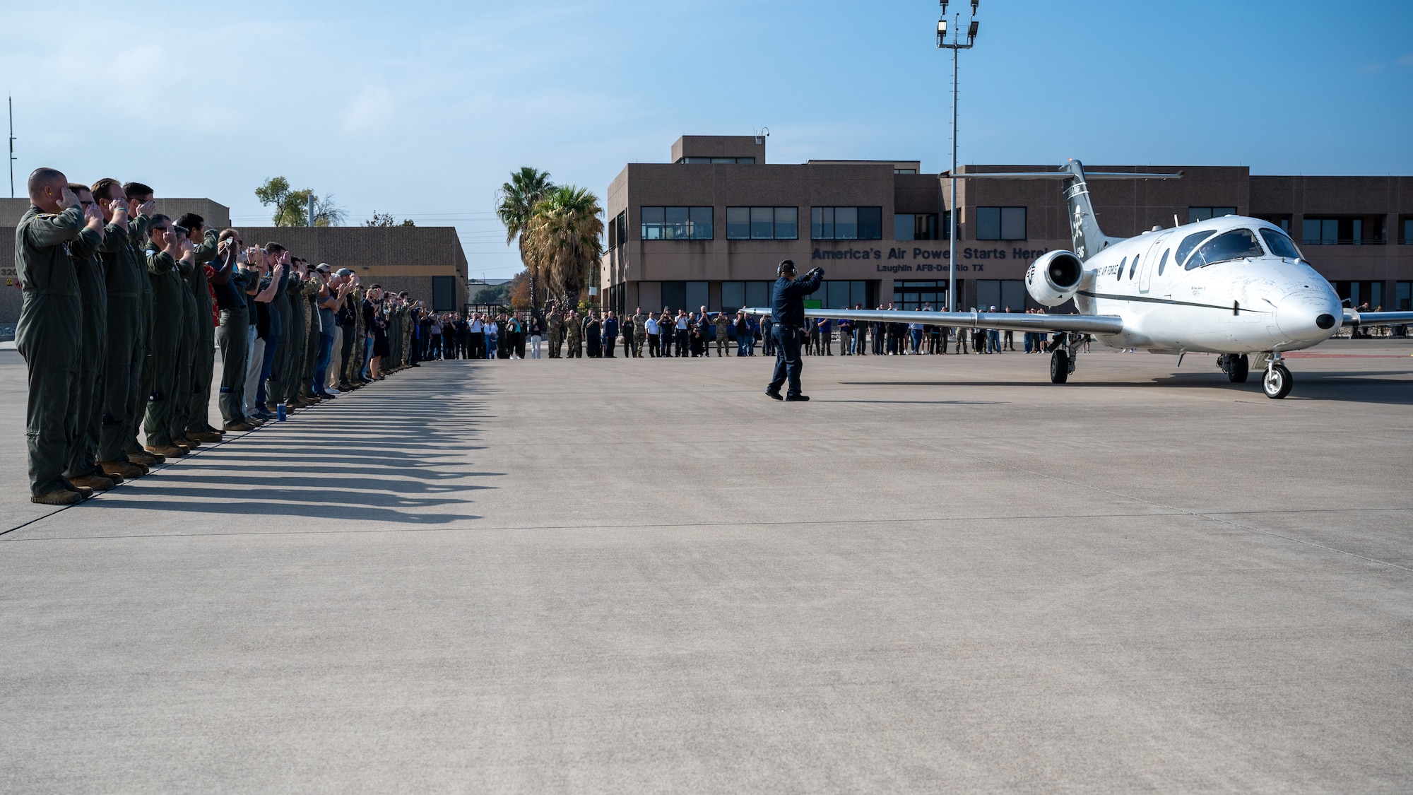 Airmen from the 86th Flying Training Squadron give a final salute to the T-1A Jayhawk as it taxis away at Laughlin Air Force Base, Texas, Dec. 17, 2024. The T-1A Jayhawk had a 31 year career at Laughlin, first arriving in Nov. of 1993. (U.S. Air Force photo by Staff Sgt. Nicholas Larsen)