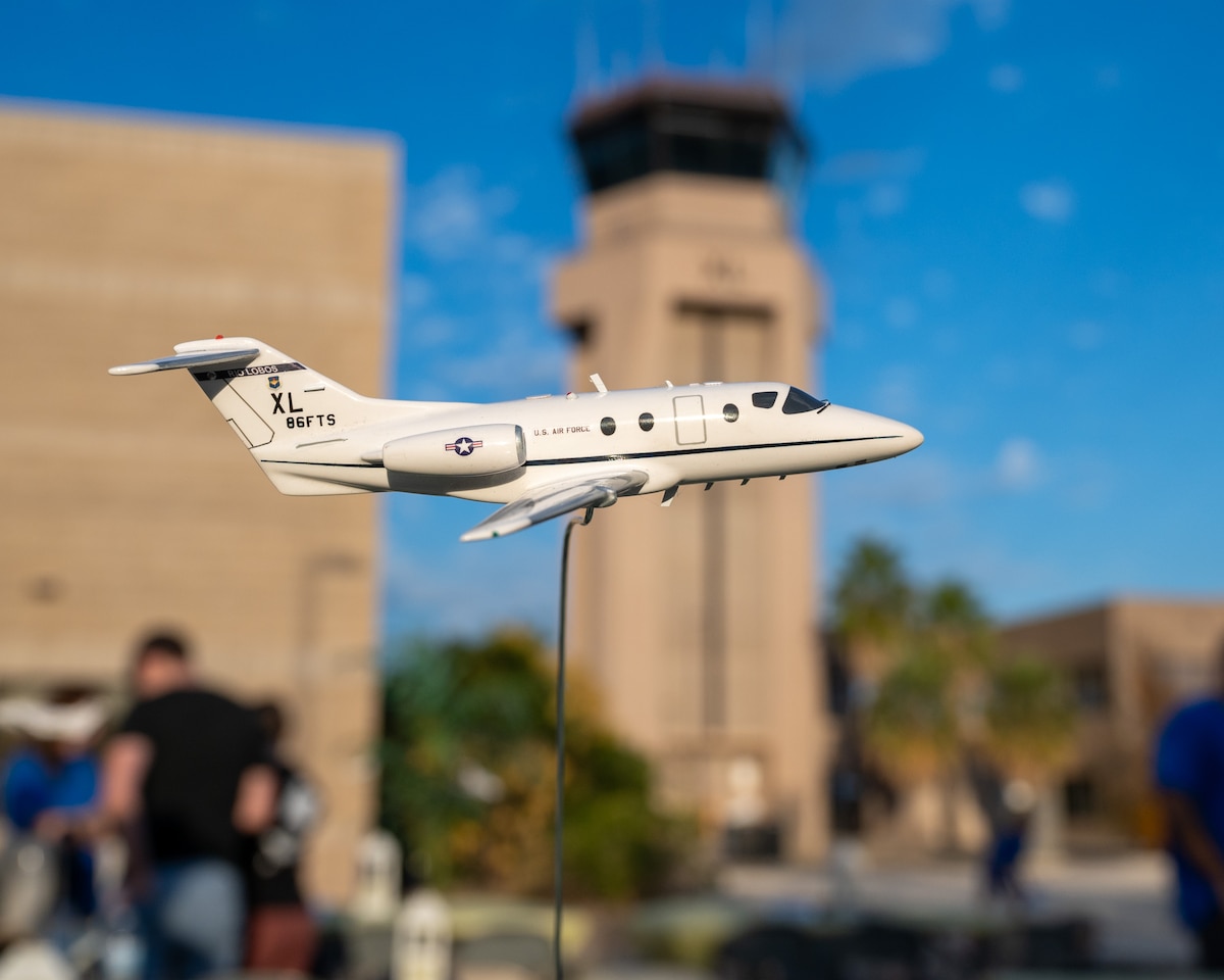 A model of the T-1A Jayhawk with the XL tower in the background at the celebration of the history of the T-1 at Laughlin Air Force Base, Texas, Dec. 16, 2024. Airmen of the 86th Flying Training Squadron held a barbecue and ceremony to celebrate the legacy of the T-1A Jayhawk. (U.S. Air Force photo by Staff Sgt. Nicholas Larsen)