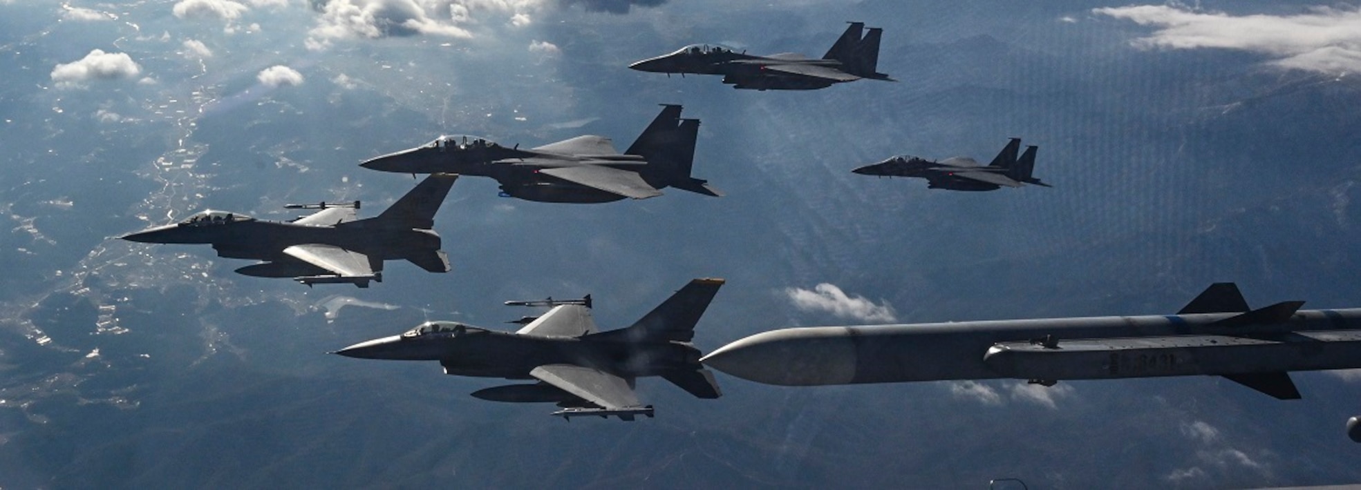 Three Republic of Korea Air Force F-15K Slam Eagle aircraft, and two U.S. Air Force F-16 Fighting Falcon aircraft fly in formation prior to conducting live munitions training in Pilsung Range, ROK, Dec. 16, 2024.