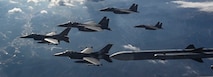 Three Republic of Korea Air Force F-15K Slam Eagle aircraft, and two U.S. Air Force F-16 Fighting Falcon aircraft fly in formation prior to conducting live munitions training in Pilsung Range, ROK, Dec. 16, 2024.