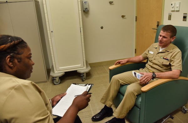 Hospital Corpsman 2nd Class Fabiola Michel, a behavioral health technician at U.S. Naval Hospital Guam’s mental health department, shares information about the Crisis Stabilization Unit program and services with Lt. Cmdr. Marvin Weniger. (U.S. Navy photo by Jaciyn Matanane/released)