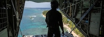 U.S. Air Force Staff Sgt. Joshua Miranda, an instructor loadmaster with the 36th Airlift Squadron at Yokota Air Base, Japan, watches the descent of three low-cost, low-altitude airdrop bundles containing humanitarian-type goods over Mogmog, Federated States of Micronesia, Dec. 10, 2024,