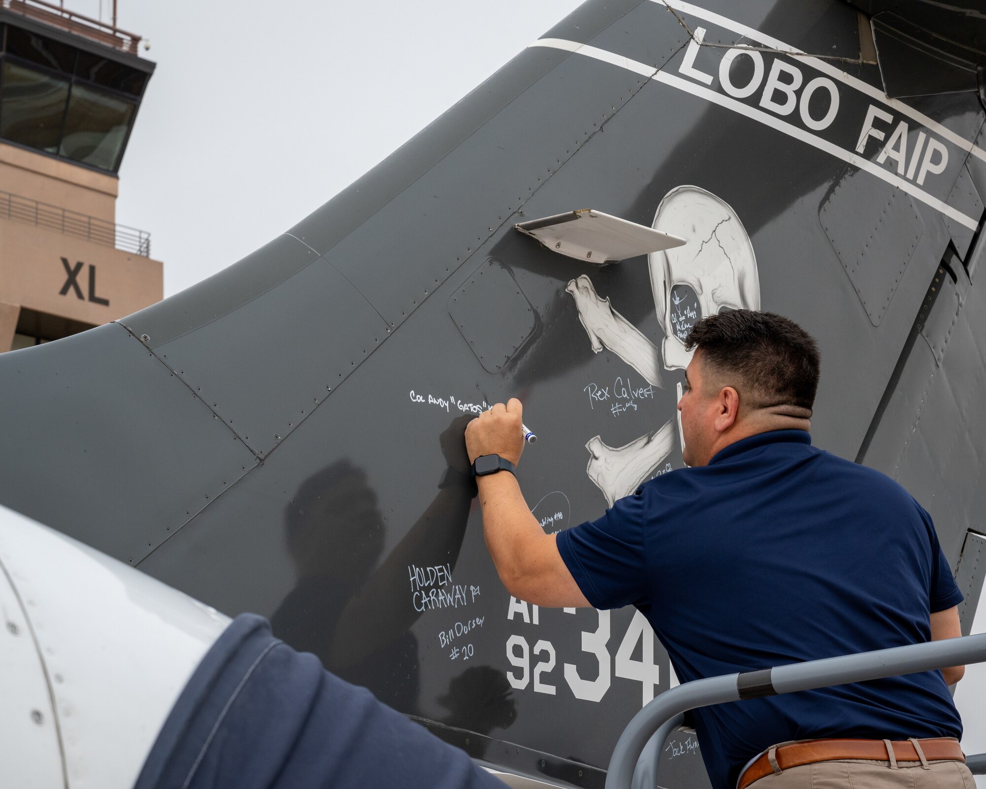 U.S. Air Force retired Col Andy "Gatos" Katz signs the tail of the last T-1A Jayhawk, before its final departure at Laughlin Air Force Base, Texas, Dec. 17, 2024. When signing the aircraft, First Assignment Instructor Pilots signed the aircraft in white markers while other Airmen signed in black markers. (U.S. Air Force photo by Staff Sgt. Nicholas Larsen)