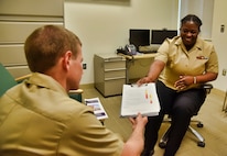 Hospital Corpsman 2nd Class Fabiola Michel, a behavioral health technician at U.S. Naval Hospital Guam’s mental health department, shares information about the Crisis Stabilization Unit program and services with Lt. Cmdr. Marvin Weniger. (U.S. Navy photo by Jaciyn Matanane/released)