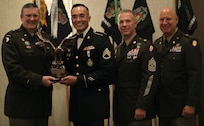 Brig. Gen. Lenny Williams, the assistant adjutant general - Army of the Illinois National Guard and the commander of the Illinois Army National Guard, State Command Sgt. Maj. Michael Kelly, and State Command Chief Warrant Officer CW5 Thomas Black present Staff Sgt. Francisco Orozco with an award at the Illinois Army National Guard's Recruiting and Retention Battalion's annual awards banquet Nov.16, 2024, in Peoria. Orozco was the Illinois Army National Guard's Recruiting and Retention Noncommissioned Officer of the Year with 35 enlistments.