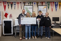 Madelyn Breeden, a recipient of the Naval Reserve Officers Training Corps scholarship, poses for a photograph with her family during a scholarship presentation in Shingle Springs, California, Dec. 20, 2024. Breeden was awarded a $180,000 scholarship into the NROTC program.  The intent of the NROTC Scholarship Program is to educate and train highly qualified young men and women for careers as commissioned officers in the Marine Corps and Naval service. (U.S. Marine Corps photo by Staff Sgt. Ryan Harvey)