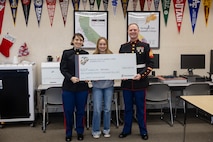 Madelyn Breeden, a recipient of the Naval Reserve Officers Training Corps scholarship, poses for a photograph with U.S. Marine Corps Capt. Isabel Billinge, executive officer of Recruiting Station Sacramento, and Sgt. Tyler Dennis, a canvassing recruiter with RS Sacramento, during a scholarship presentation in Shingle Springs, California, Dec. 20, 2024. Breeden was awarded a $180,000 scholarship into the NROTC program.  The intent of the NROTC Scholarship Program is to educate and train highly qualified young men and women for careers as commissioned officers in the Marine Corps and Naval service. (U.S. Marine Corps photo by Staff Sgt. Ryan Harvey)