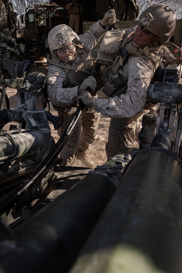 U.S. Marine Corps Lance Cpl. Jeremy Chew, a West Chester, Pennsylvania native, left, and Pfc. Joseph Moreno, a Dallas, Texas native, both field artillery cannoneers with 2nd Marine Battalion, 11th Marine Regiment, 1st Marine Division, prepare an M777 Howitzer to fire during a Fire Support Coordination Exercise II as a part of Service Level Training Exercise 0-25 at Training Area Quackenbush, Marine Corps Air-Ground Combat Center, Twentynine Palms, California, Dec. 5, 2024. FSCEX is a live-fire training event integrating infantry battalion combat operations center functions, distributed artillery, mobile fire support teams, close air support assets, and electronic warfare support teams. SLTE 0-25 is designed to enhance readiness across core Mission Essential Tasks and prepare Marines for high-end Force-on-Force operations. (U.S. Marine Corps photo by Cpl. Aidan Jones)