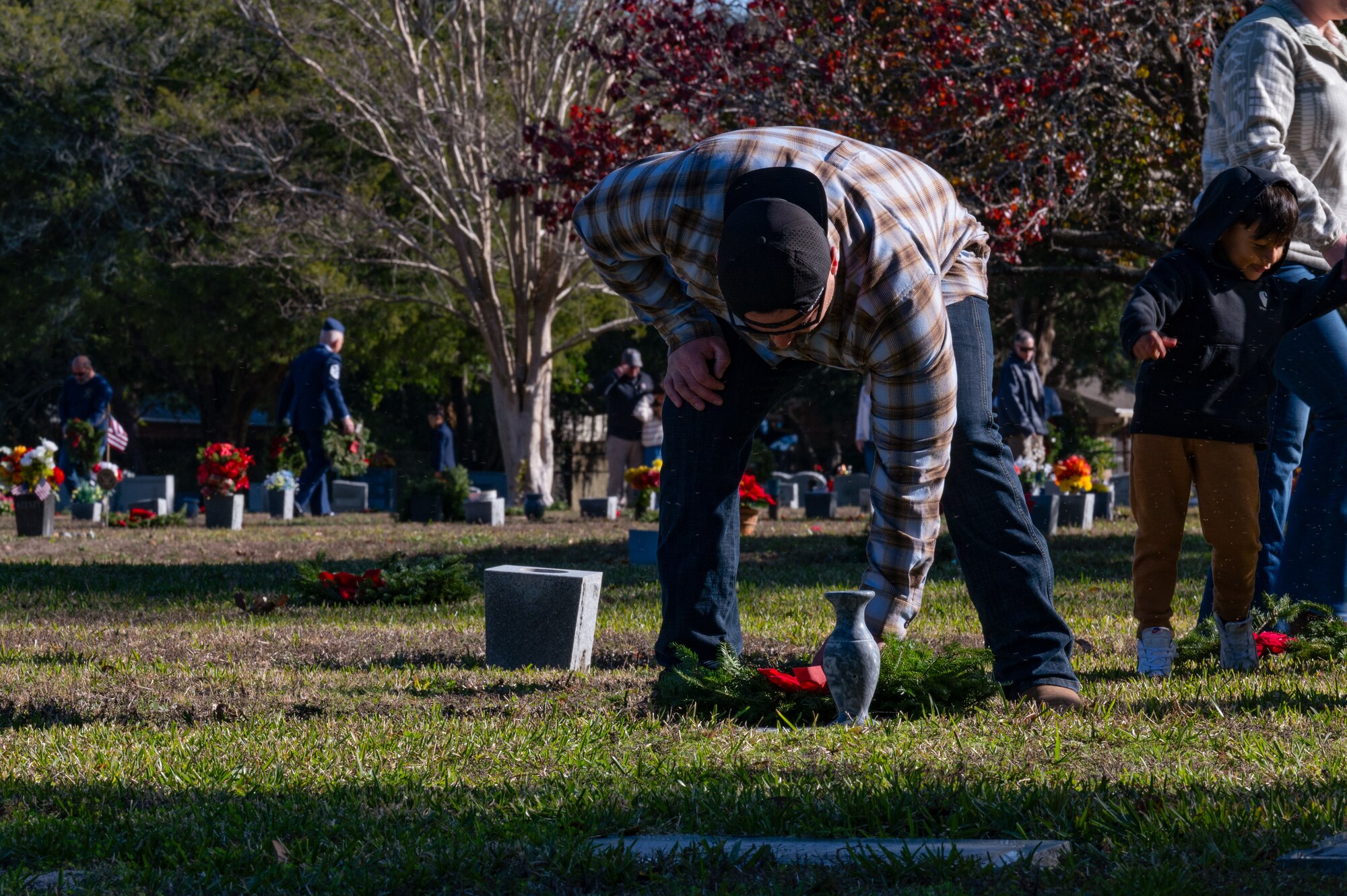 A member of the local community places a ceremonial wreath on a veteran’s gravestone during the Wreaths Across America Placement Ceremony at Beal Memorial Cemetery, Florida, Dec. 14, 2024.