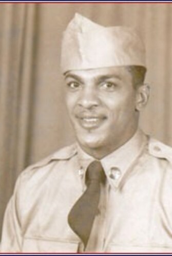 A man poses for a portrait photo wearing combat uniform.