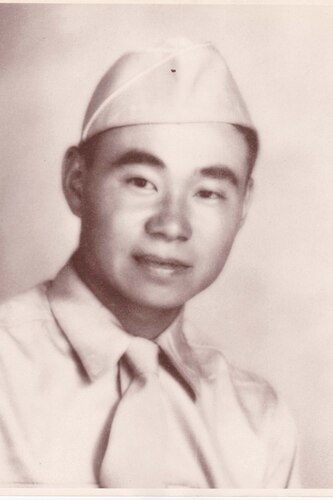 A man poses for a portrait photo wearing combat uniform.