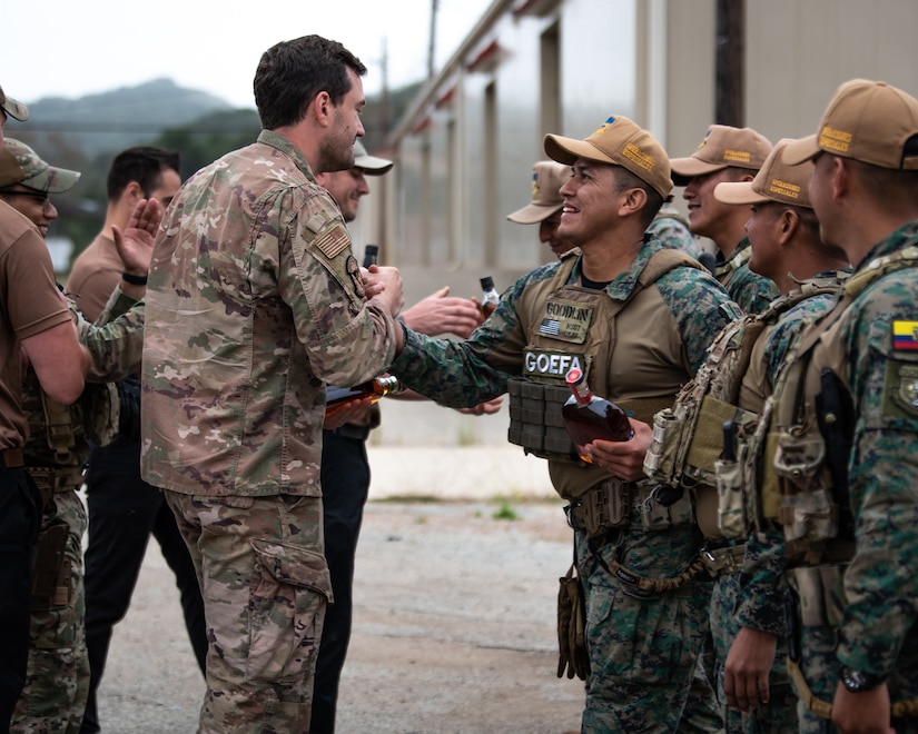 Members of the Kentucky Air National Guard’s 123rd Security Forces Squadron trade gifts with a team from the Ecuadorian Air Force Special Operations Command as part of an information exchange event between the two groups at Camp San Luis Obispo, Calif., May 20, 2024.