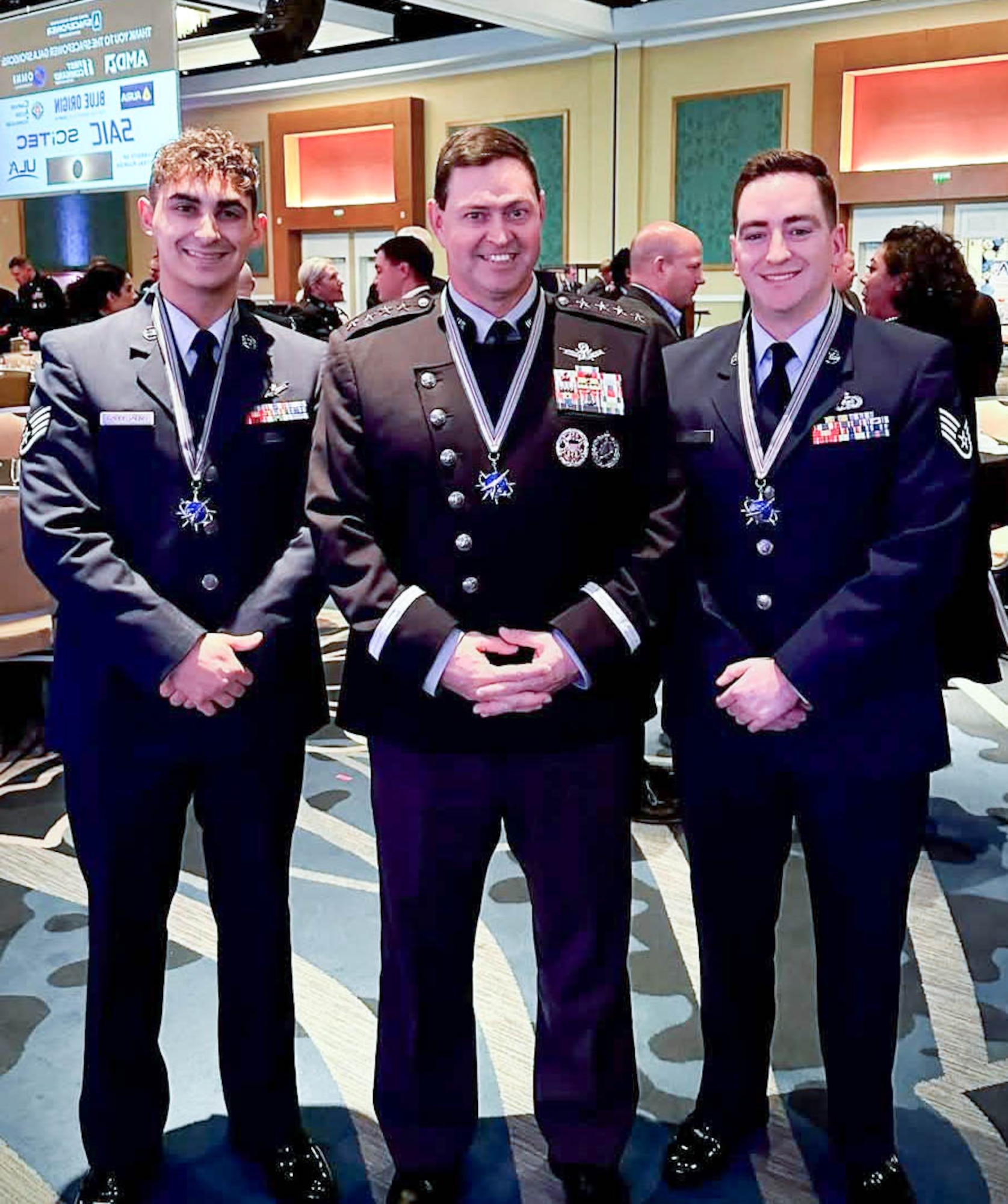 Staff Sgt. Jason Capostagno, left, and Staff Sgt. Curtis Grady, right, with the New York Air Guard’s 222nd Command and Control Squadron, stand with Gen B. Chance Saltzman, chief of Space Operations, U.S. Space Force, at the Space Force Association's Spacepower Conference in Orlando Fla., Dec.10-12, 2024. Capostagno was named the winner of the Space category, while Grady won the Intelligence category award.