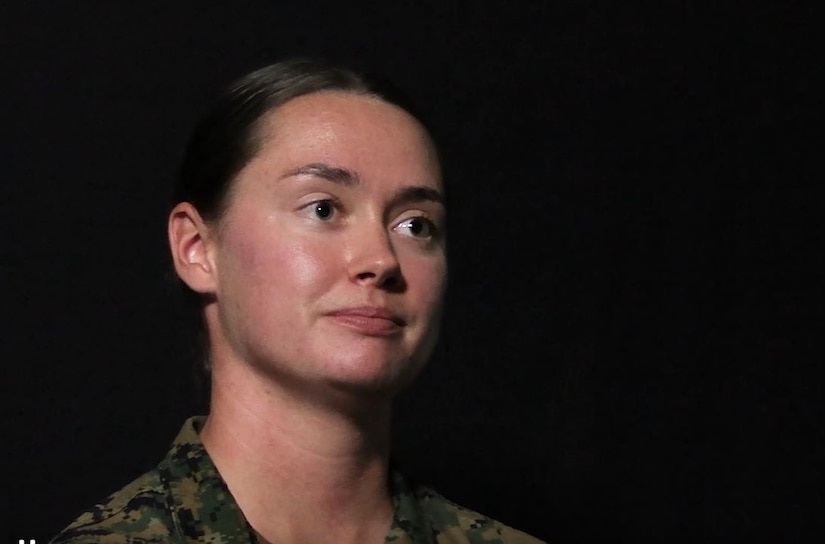 A Marine is pictured against a dark background.