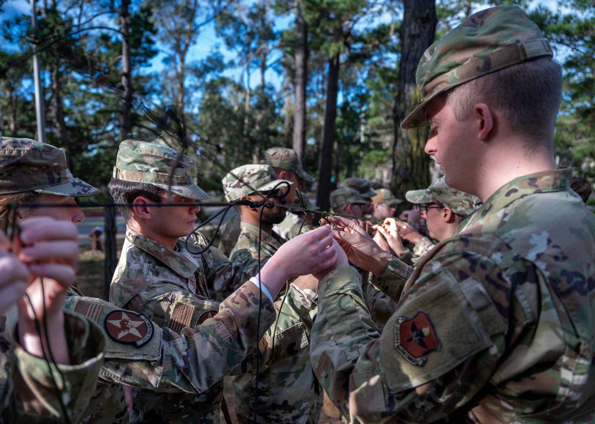 Airmen practice knot tying during survival, evasion, resistance, and escape training during a deployment readiness exercise, Presidio of Monterey, Calif., Jan. 6, 2025. SERE is a vital training that equips service members with essential skills to endure and operate in high-risk, hostile, or isolated environments. (U.S. Air Force photo by Senior Airman Sarah Williams)