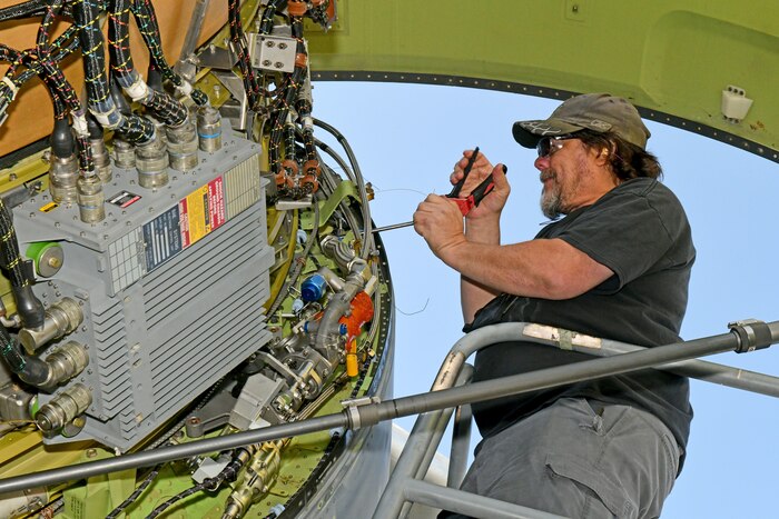 aircraft mechanic working on airplane engine
