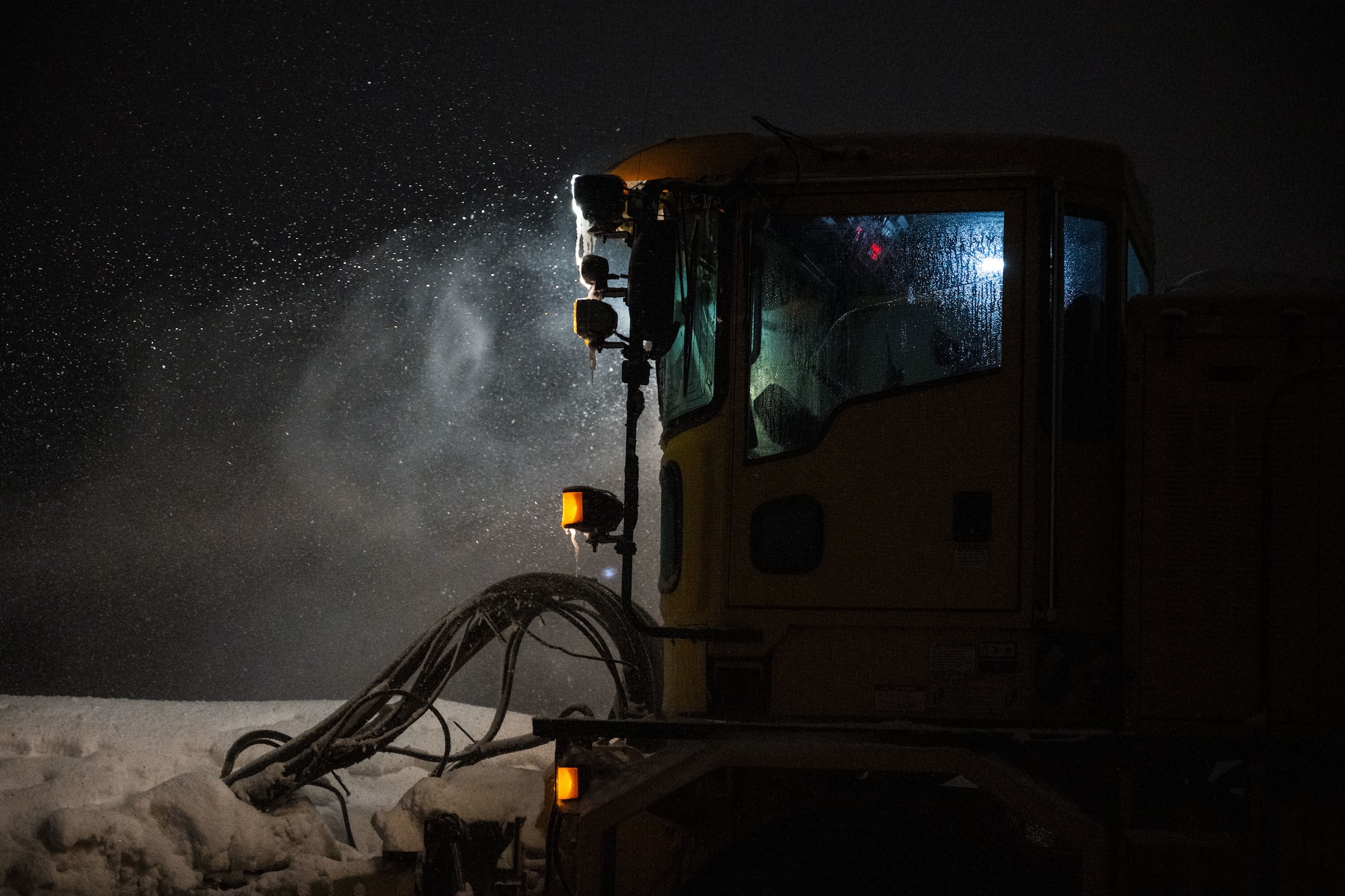 A member of the 316th Civil Engineer Squadron operates a snowplow.