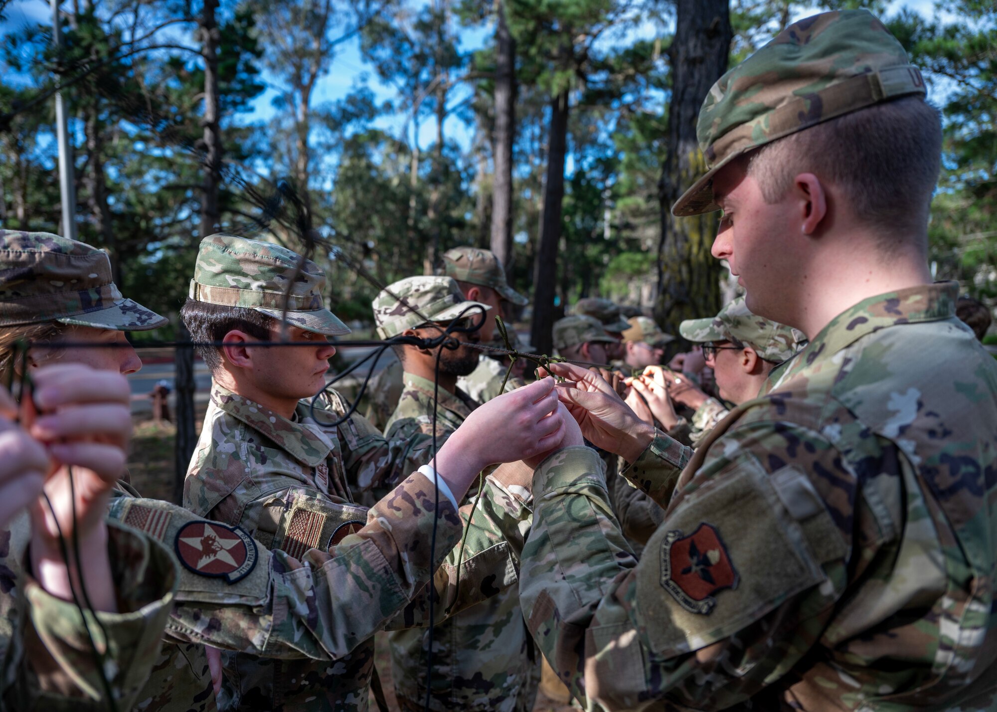 Airmen practice knot tying during survival, evasion, resistance, and escape training during a deployment readiness exercise, Presidio of Monterey, Calif., Jan. 6, 2025. SERE is a vital training that equips service members with essential skills to endure and operate in high-risk, hostile, or isolated environments. (U.S. Air Force photo by Senior Airman Sarah Williams)