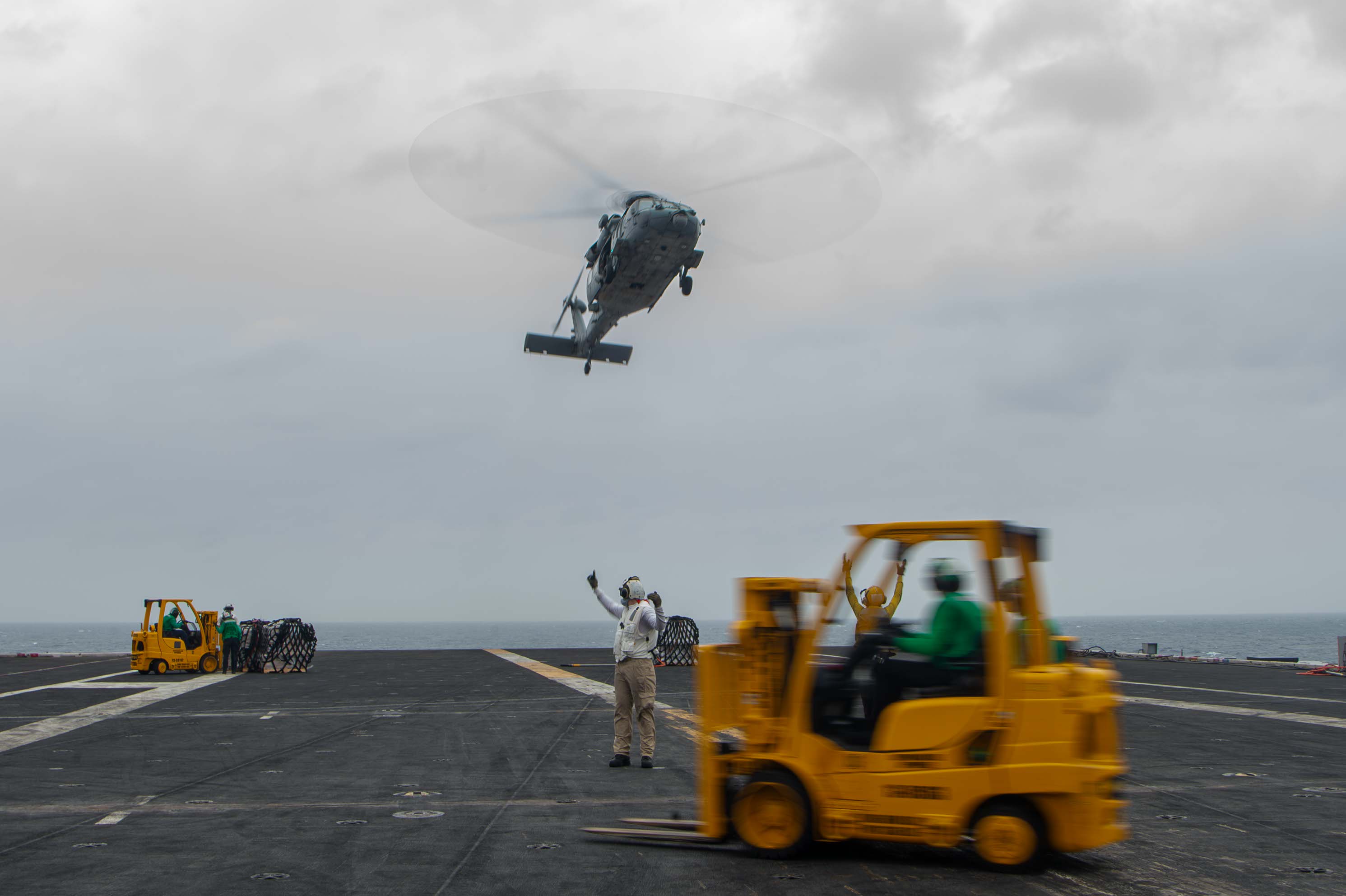 Sailors receive stores delivered by an MH-60S Seahawk, assigned to the “Black Knights” of Helicopter Sea Combat Squadron (HSC) 4, on the flight deck aboard the Nimitz-class aircraft carrier USS Carl Vinson (CVN 70) during a vertical replenishment-at-sea with the Lewis and Clark-class dry cargo and ammunition ship USNS Richard E. Byrd (T-AKE 4), Jan. 5, 2025.