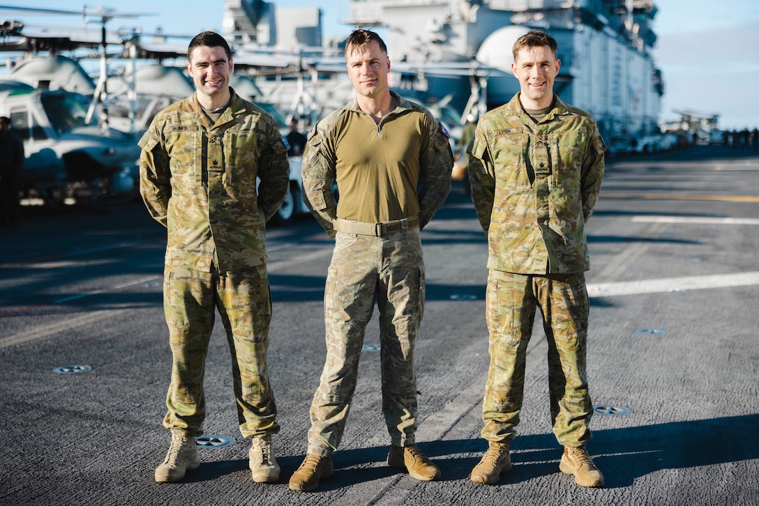 From left to right, Australian Army Maj. Jack Jones, the assistant logistics officer assigned to the 15th Marine Expeditionary Unit; Maj. Rhys Davies, an AH-1Z Viper pilot assigned to Marine Medium Tiltrotor Squadron (VMM) 165 (Reinforced), 15th MEU; and Maj. George Lynn, the assistant operations officer assigned to the 15th MEU, pose for a photo aboard the amphibious assault ship USS Boxer (LHD 4) while underway in the Pacific Ocean Nov. 21, 2024. Jones, Davies, and Lynn served as foreign exchange officers with the 15th MEU through the Marine Corps Personnel Exchange Program, and recently completed a deployment with the 15th MEU to the Indo-Pacific region. (U.S. Marine Corps photo by Cpl. Luis Agostini)