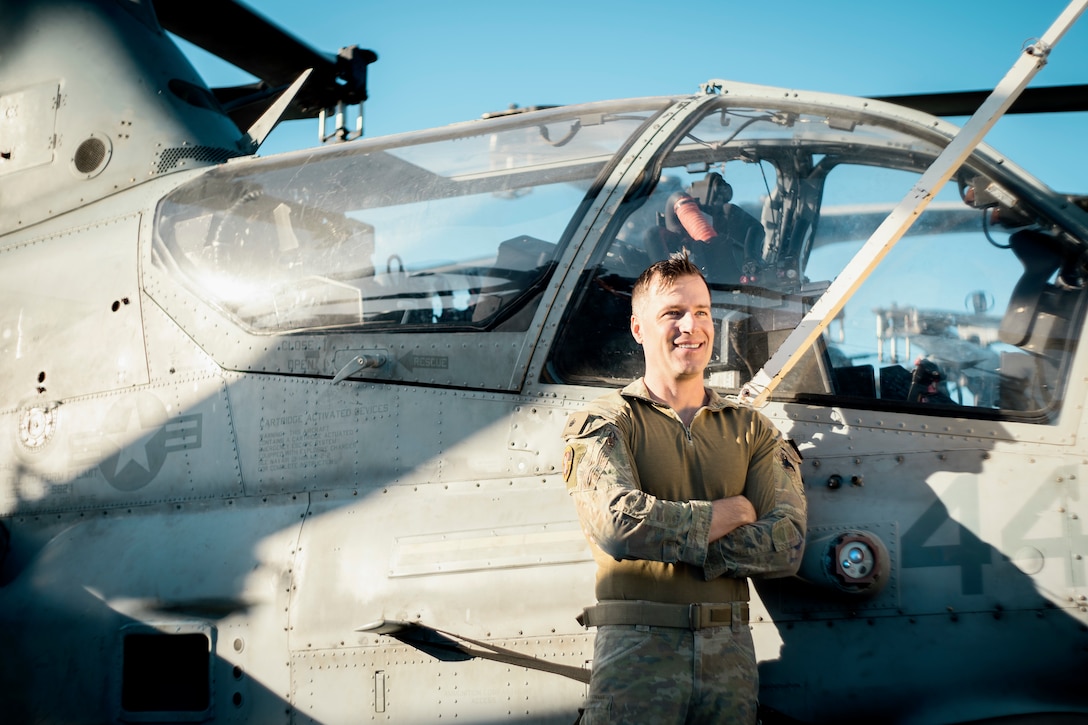 Australian Army Maj. Rhys Davies, an AH-1Z Viper pilot assigned to Marine Medium Tiltrotor Squadron (VMM) 165 (Reinforced), 15th Marine Expeditionary Unit, poses for a photo aboard the amphibious assault ship USS Boxer (LHD 4) while underway in the Pacific Ocean Nov. 21, 2024. Davies recently deployed as part of the 15th MEU’s aviation combat element through the Marine Corps Personnel Exchange Program. In the Australian Army, Davies flew the Tiger Armed Reconnaissance helicopter with 16th Aviation Brigade, 1st Aviation Regiment, and learned to pilot the AH-1Z Viper aircraft upon attaching to VMM-165 (Rein.).  (U.S. Marine Corps photo by Gunnery Sgt. Donald Holbert)