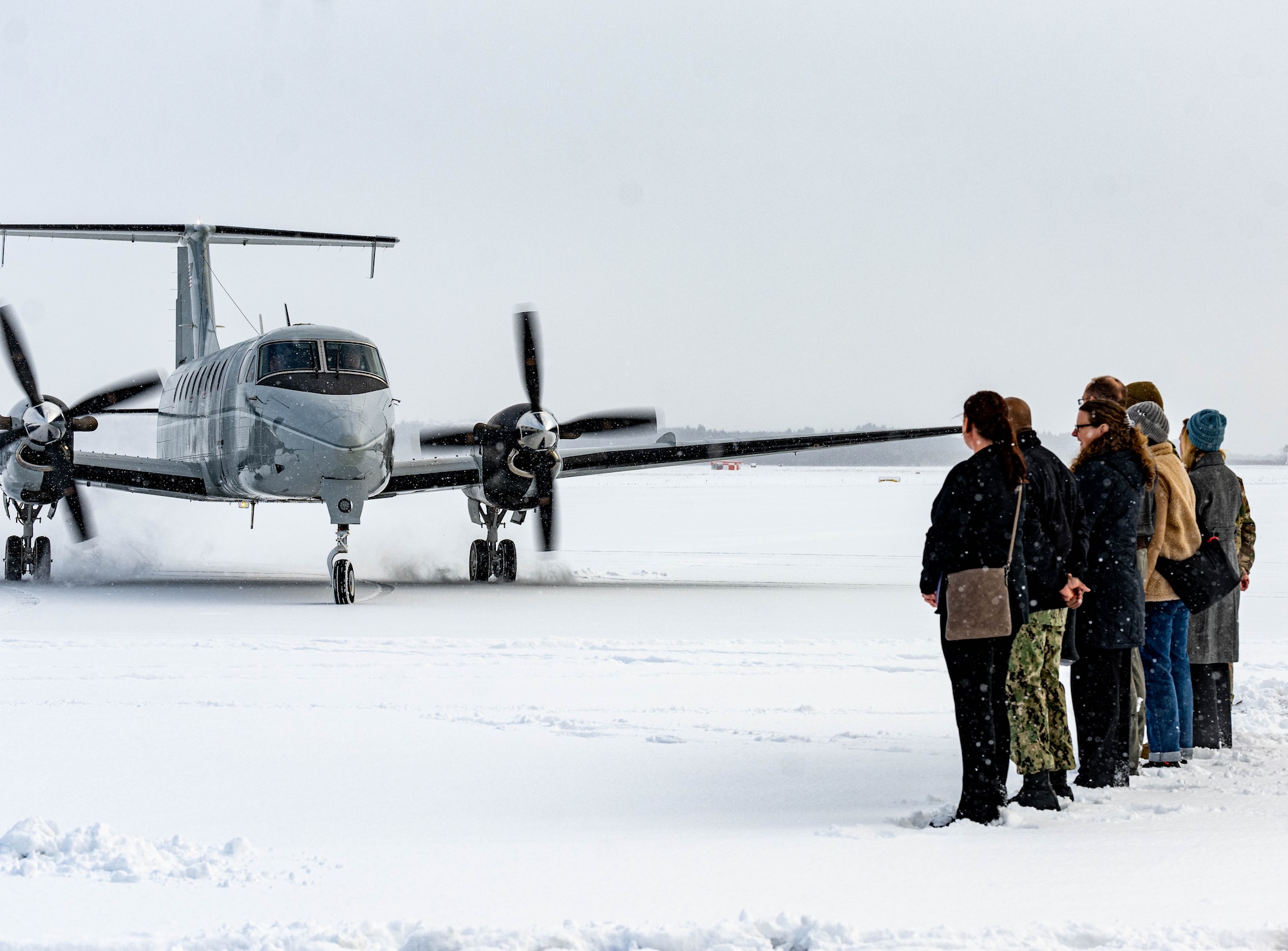 A welcome party awaits on a snowy runway for the arrival of U.S. Air Force Lt. Gen. Stephen Jost, U.S. Forces Japan and 5th Air Force commander, at Misawa Air Base, Japan, Dec. 16, 2024. Jost visited the installation to engage with leaders and members of the community to assess operational capabilities and infrastructure, ensuring informed decision-making on projects pertaining to mission readiness, quality of life and bilateral alliance. (U.S. Air Force photo by Staff Sgt. Kelsea Caballero)