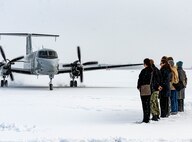 A welcome party awaits on a snowy runway for the arrival of U.S. Air Force Lt. Gen. Stephen Jost, U.S. Forces Japan and 5th Air Force commander, at Misawa Air Base, Japan, Dec. 16, 2024. Jost visited the installation to engage with leaders and members of the community to assess operational capabilities and infrastructure, ensuring informed decision-making on projects pertaining to mission readiness, quality of life and bilateral alliance. (U.S. Air Force photo by Staff Sgt. Kelsea Caballero)