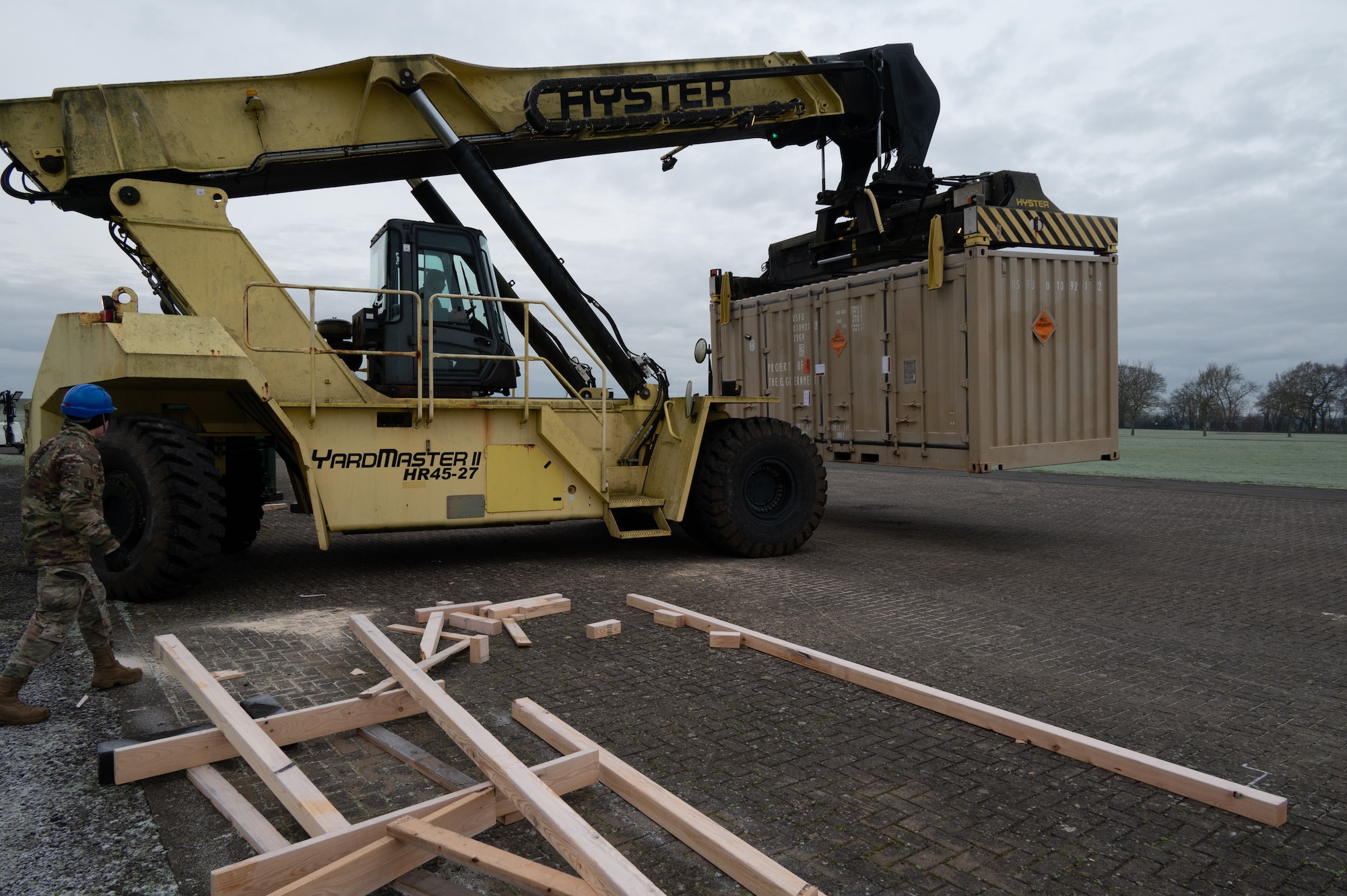 A service member from the 420th Munitions Squadron operates a reach stacker