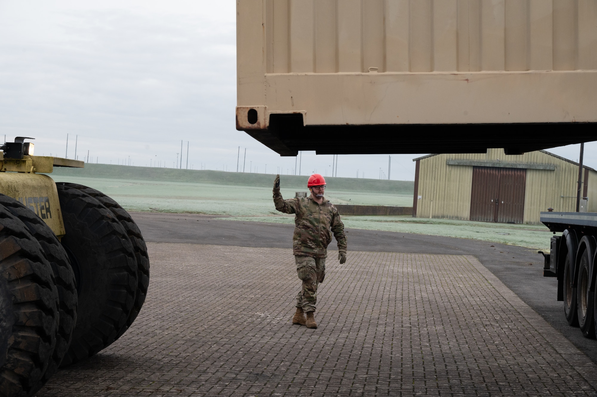 A service member from the 420th Munitions Squadron guides a reach stacker