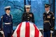 Three ceremonial guard service members stand at attention while standing watch over the flag-draped casket of former President Jimmy Carter.