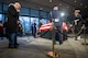 A man bows his head (left) while standing near the flag-draped casket of former President Jimmy Carter while it is lying in repose and being guarded by a team of ceremonial guard members, one from each branch of the armed forces.